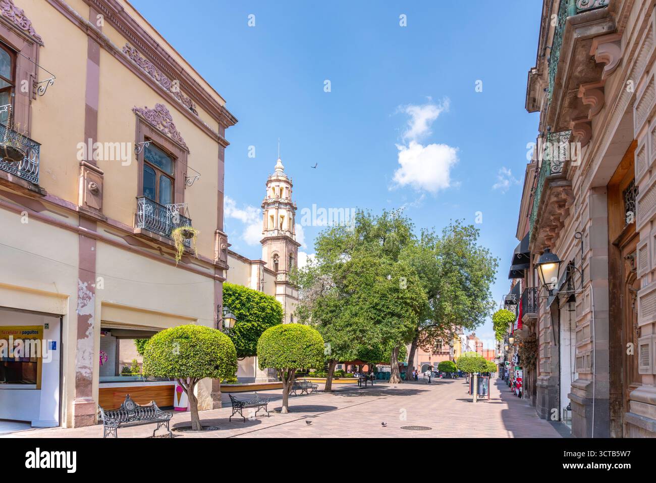 La strada è fiancheggiata da edifici, tra cui uno alto con una chiesa al centro. Centro storico di Queretaro, architettura coloniale, decorazioni Foto Stock