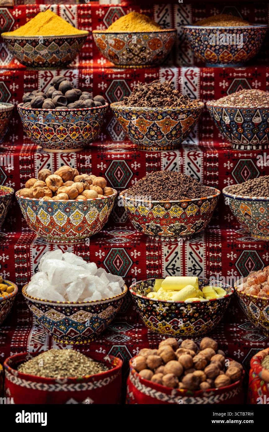 Una disposizione esotica e colorata di prodotti tradizionali dell'Oman in vendita, tra cui erbe aromatiche, noci intere e polveri di spezie. Foto Stock