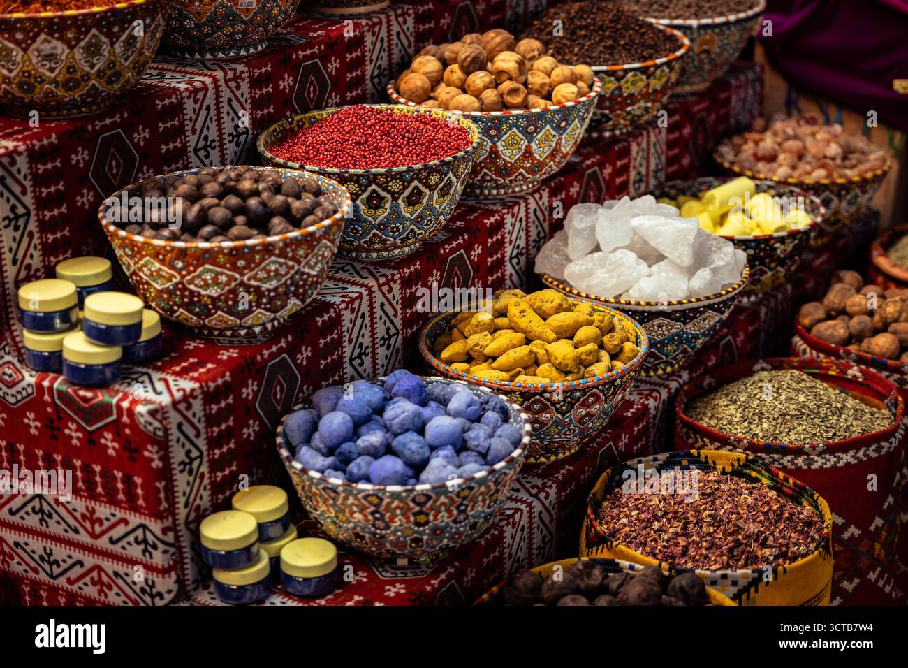 Una disposizione esotica e colorata di prodotti tradizionali dell'Oman in vendita, tra cui erbe aromatiche, noci intere e polveri di spezie. Foto Stock