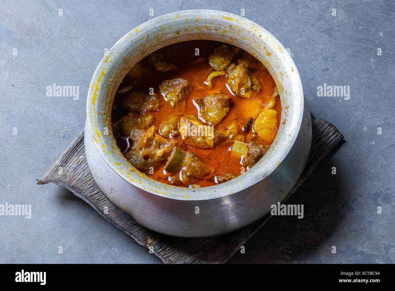 Primo piano di saporiti e aromatici curry di manzo del Bangladesh in una pentola d'argento. Piatto tradizionale a base di carne piccante e a cottura lenta, popolare in Asia meridionale. Autentico hom Foto Stock