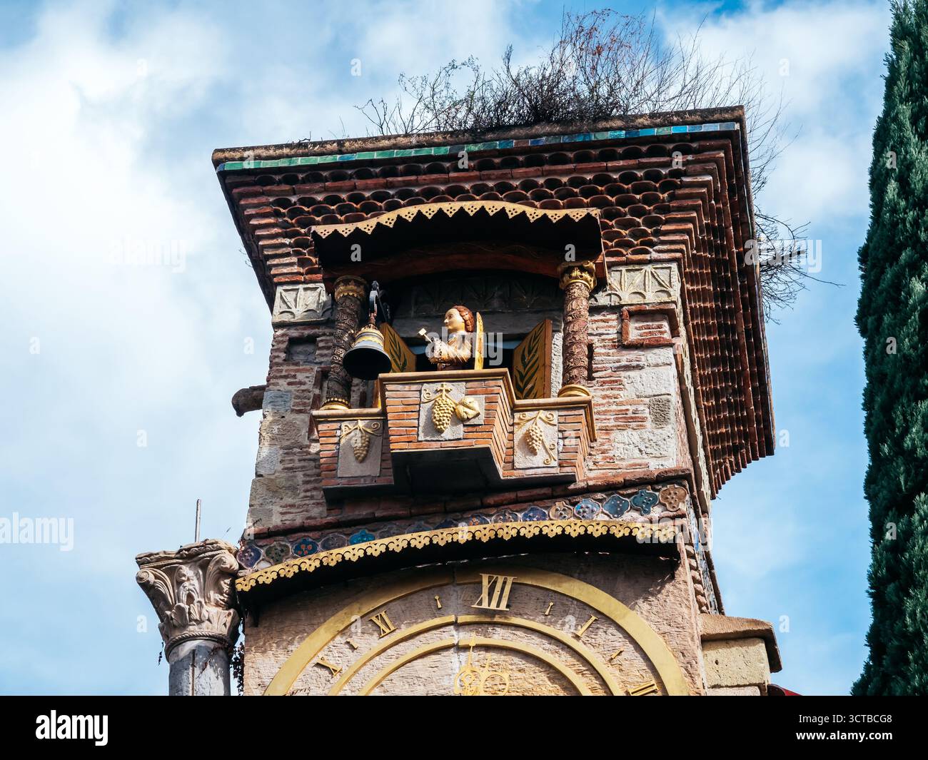 Primo piano di un burattino animato che suona il campanello in cima alla Torre dell'orologio pendente a Tbilisi, Georgia, che mette in mostra la cura artigianale dettagliata e il design stravagante Foto Stock