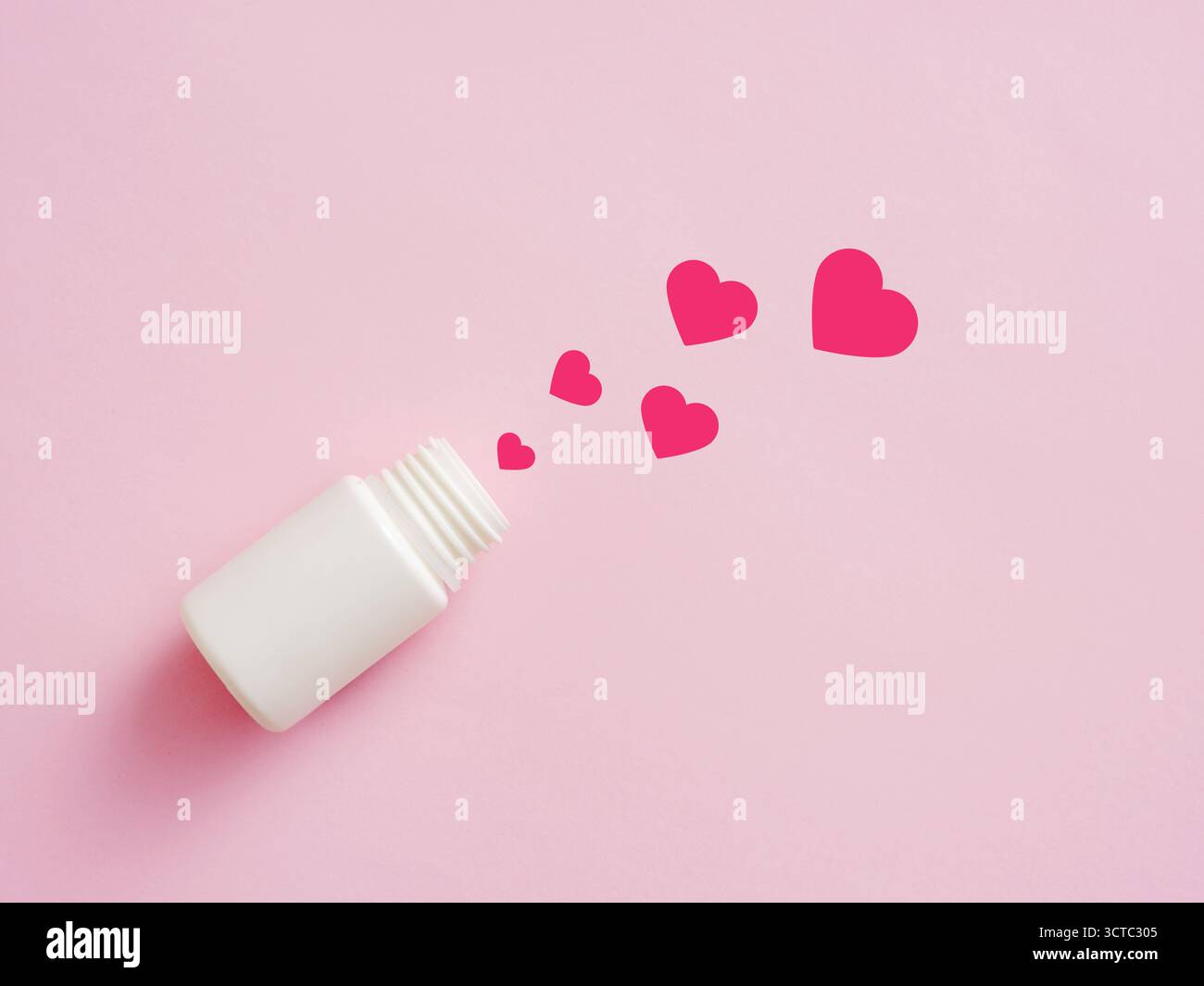 Forme di cuore che fuoriescono da una bottiglia di medicina bianca su uno sfondo rosa, simboleggiano una cura per la malattia d'amore Foto Stock