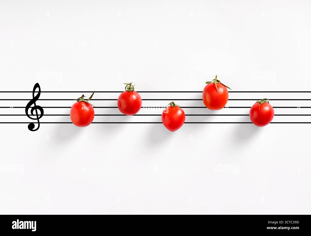 Pomodori ciliegini che formano note musicali su uno sfondo bianco con un G clef, che rappresenta un concetto alimentare creativo Foto Stock
