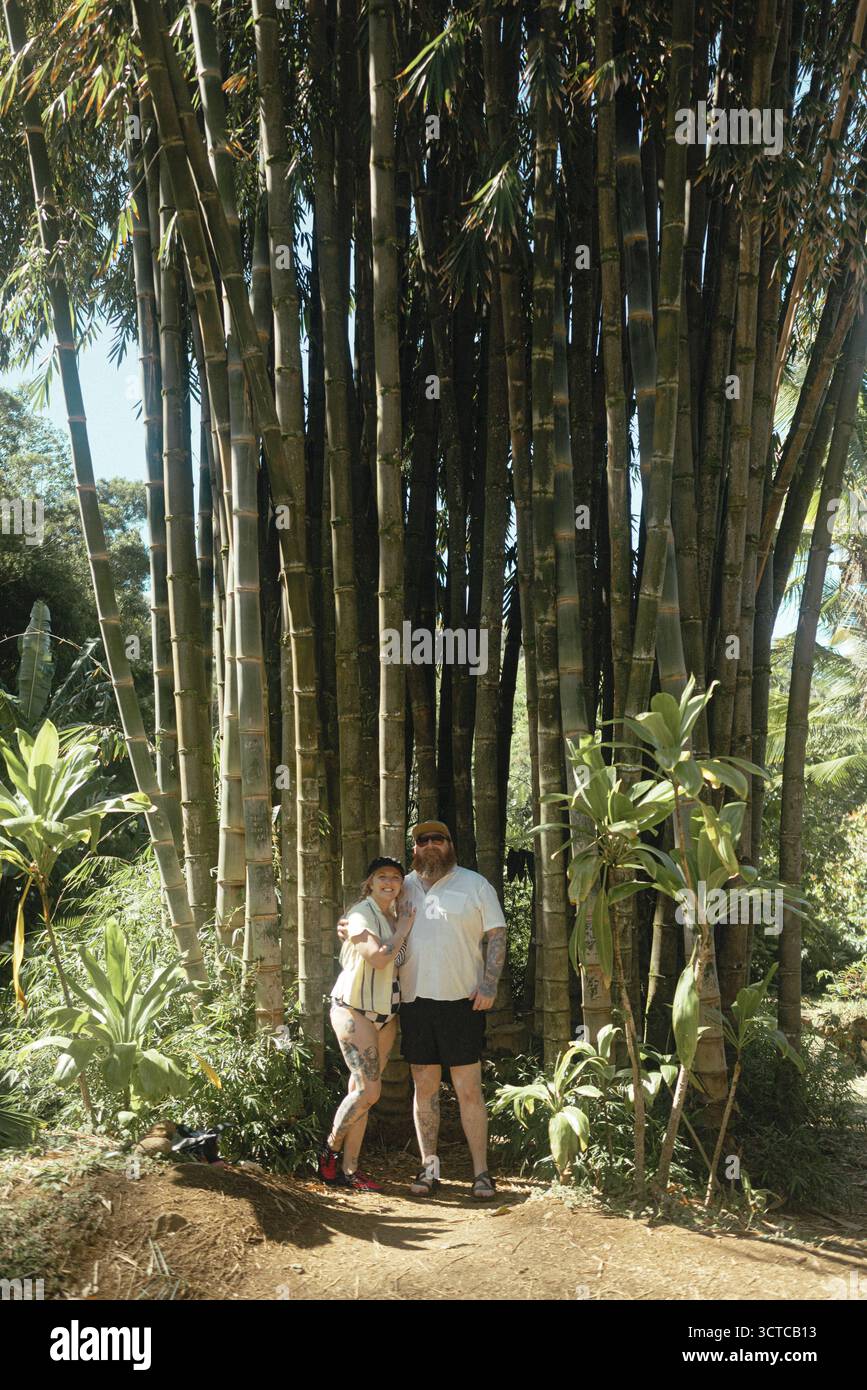 La coppia sta insieme sotto il torreggiante boschetto di bambù a Maui Foto Stock