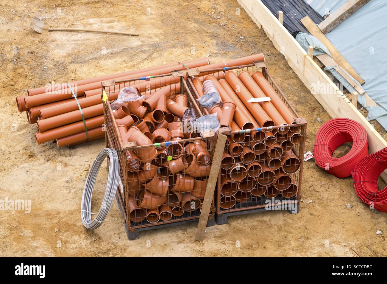 Tubi idraulici e di drenaggio con raccordi e utensili in cantiere all'aperto Foto Stock