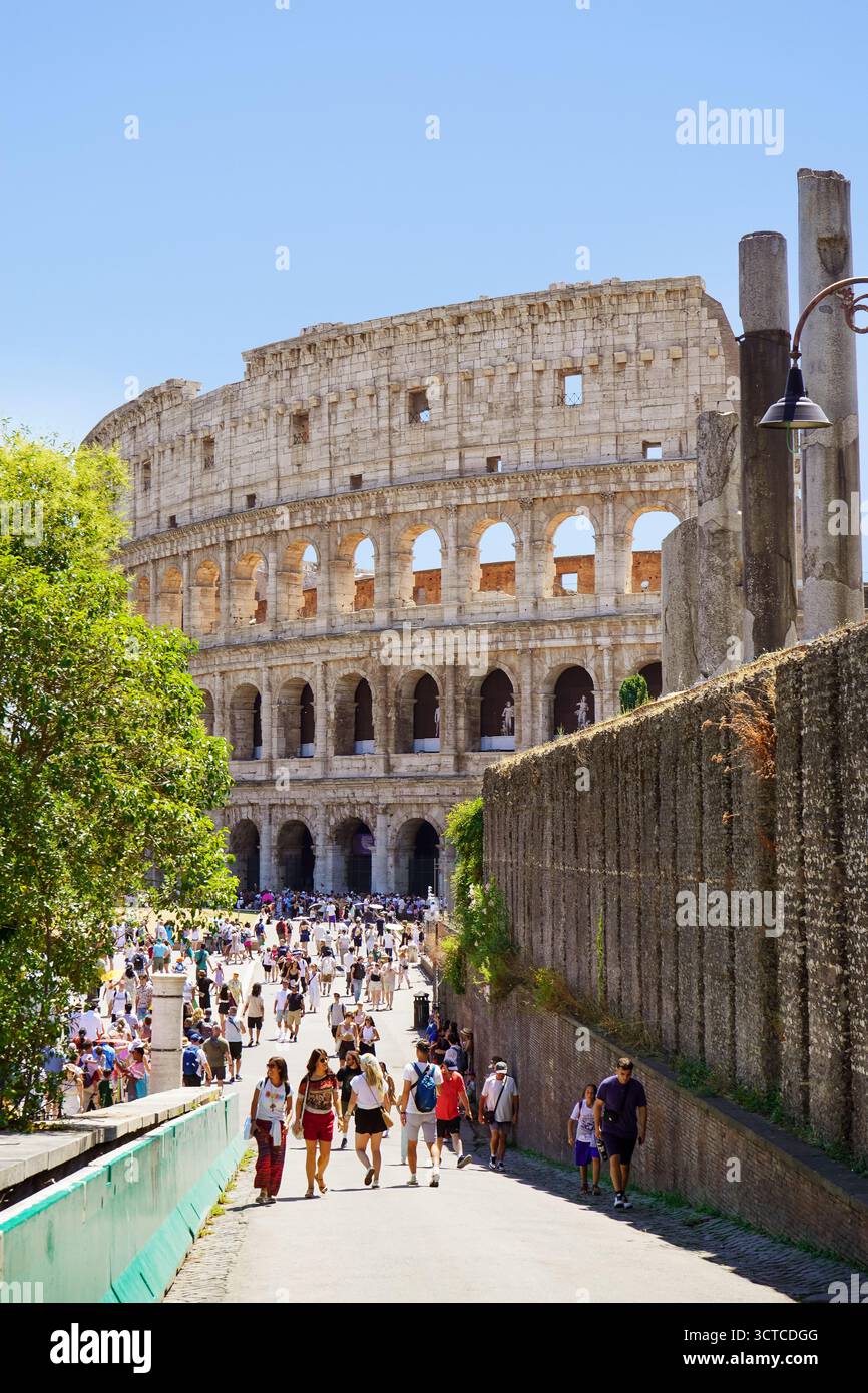 Turisti su un marciapiede fuori dal Colosseo Romano Foto Stock