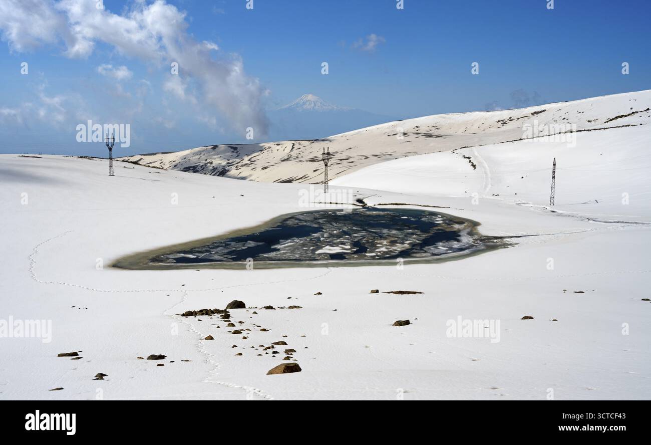 Paesaggio innevato con lago ghiacciato e cielo azzurro, lago Ashot Orujyan, sullo sfondo Monte Ararat in Turchia, Aragaz, Aragats, Aragac, Alagyaz, e Foto Stock