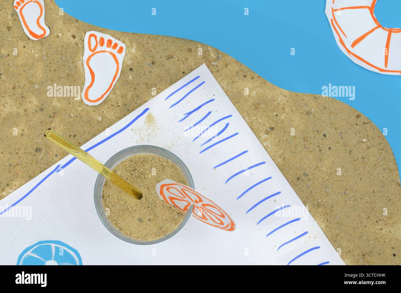 Supporti misti:foto combinata con disegno. Presentazione insolita di un drink in spiaggia. Al posto del succo c'è sabbia in un bicchiere. Foto Stock