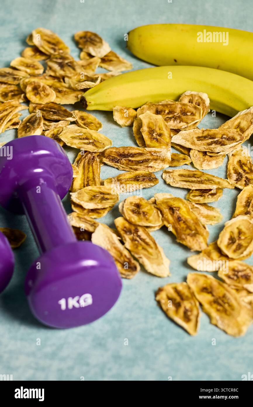Migliora il tuo contenuto visivo con questa immagine, che incarna l'essenza di uno stile di vita sano. Centrato intorno a manubri che simboleggiano la forma fisica e il fregio Foto Stock