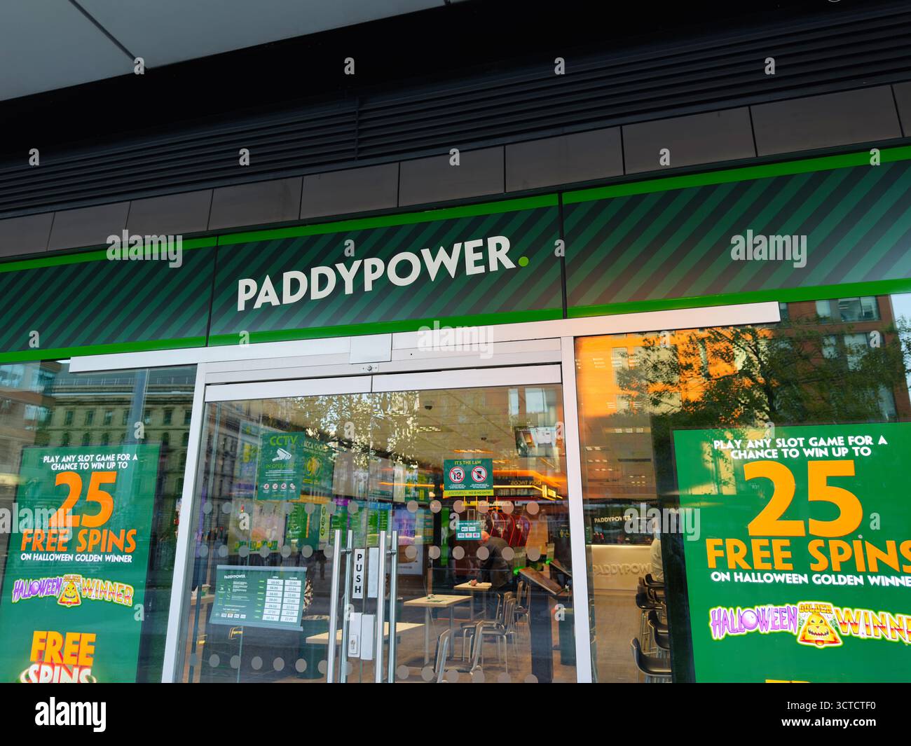 Manchester, Regno Unito - 25 settembre 2025: Luminoso negozio di scommesse esterno con marchio verde e grandi poster che pubblicizzano giri gratuiti e promozioni. Foto Stock