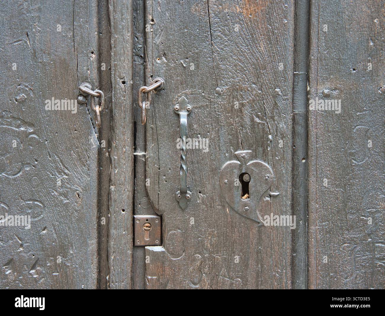 Porta in legno con serratura a cuore - primo piano di una vecchia porta in legno scuro con serratura a forma di cuore e antichi ferramenta in ferro. Foto Stock