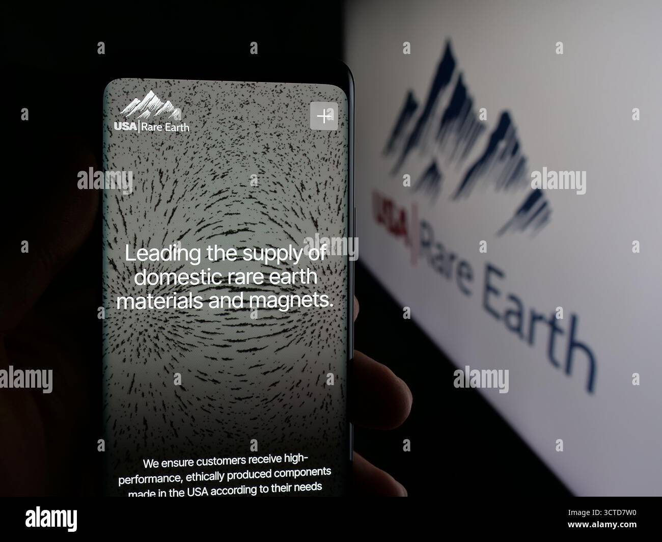 Stoccarda, Germania - 10-04-2025: Persona con smartphone e pagina web della società mineraria USA rare Earth Inc. Sullo schermo davanti al logo. Foto Stock