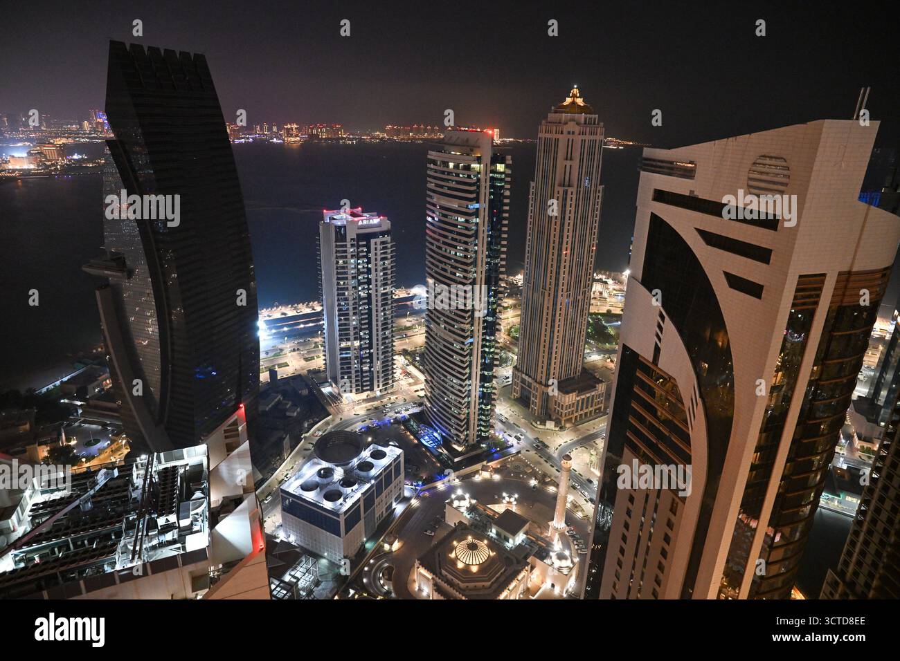 Qatar, Doha: Vista notturna del quartiere degli affari di West Bay e dei suoi grattacieli, nel cuore della baia, lungo la Corniche, che ospita vari corpor Foto Stock