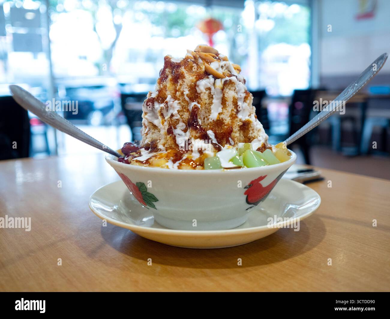 Dessert ghiacciato rasato chiamato Ice Kacang o ais kacang in Malesia con ingredienti misti di arachidi, fagioli rossi, latte, sciroppo rosso e colorata gelatina dolce. Foto Stock