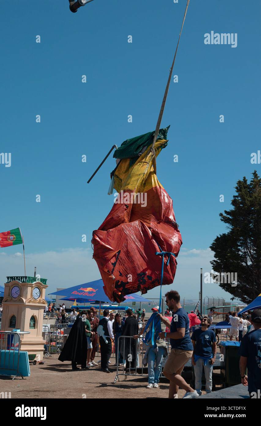 Il personale addetto all'evento recupera un'imbarcazione volante in decollo dopo il suo volo al Red Bull Flugtag di Lisbona Foto Stock