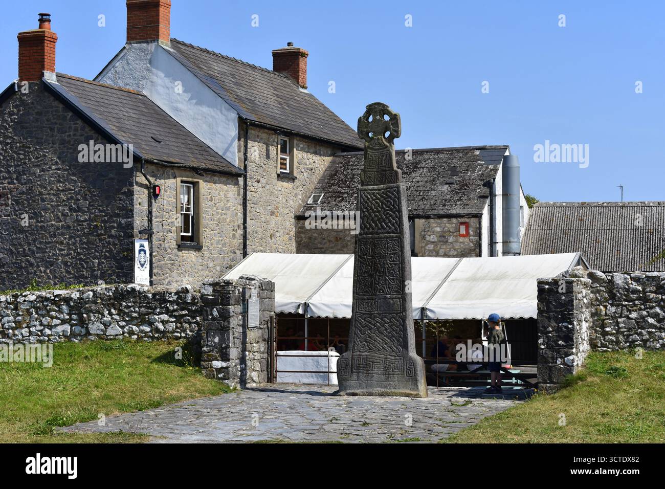 Piccolo ragazzo in piedi accanto a Carew Cross, Carew, Tenby, Galles Foto Stock