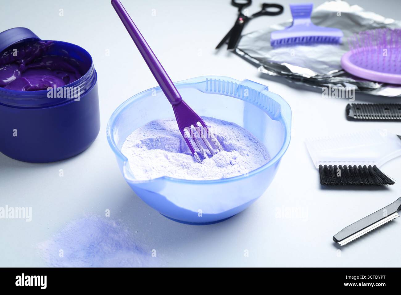 Prodotto per la cura dei capelli biondi e strumenti per parrucchieri su sfondo bianco, primo piano Foto Stock