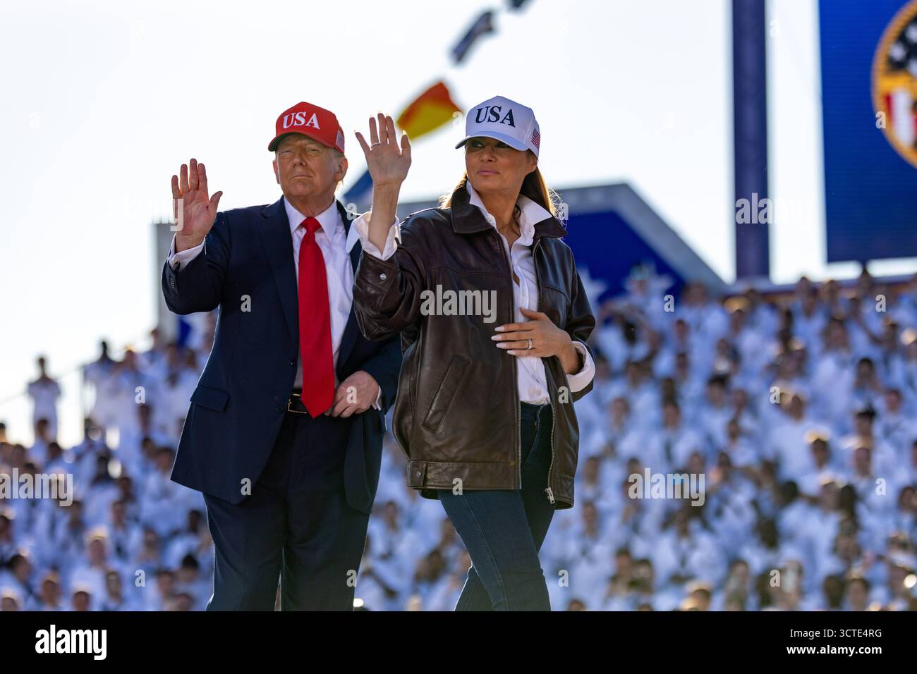 LA STAZIONE NAVALE DI NORFOLK, Virginia (5 ottobre 2025), il presidente Donald J. Trump e la First Lady Melania Trump ondeggiano verso il pubblico durante un All Hands Call al Pier 14, insieme alla portaerei classe Nimitz USS Harry S. Truman (CVN 75) e alla nave d'assalto anfibio classe Wasp USS Kearsarge (LHD 3), 5 ottobre 2025. L'All Hands Call at Naval Station Norfolk è uno dei numerosi eventi che si svolgono in tutto il paese per mostrare gli uomini e le donne che con orgoglio prestano servizio nella Marina degli Stati Uniti. (Foto della Marina degli Stati Uniti di Justin Kemble, specialista di comunicazione di massa di seconda classe) Foto Stock