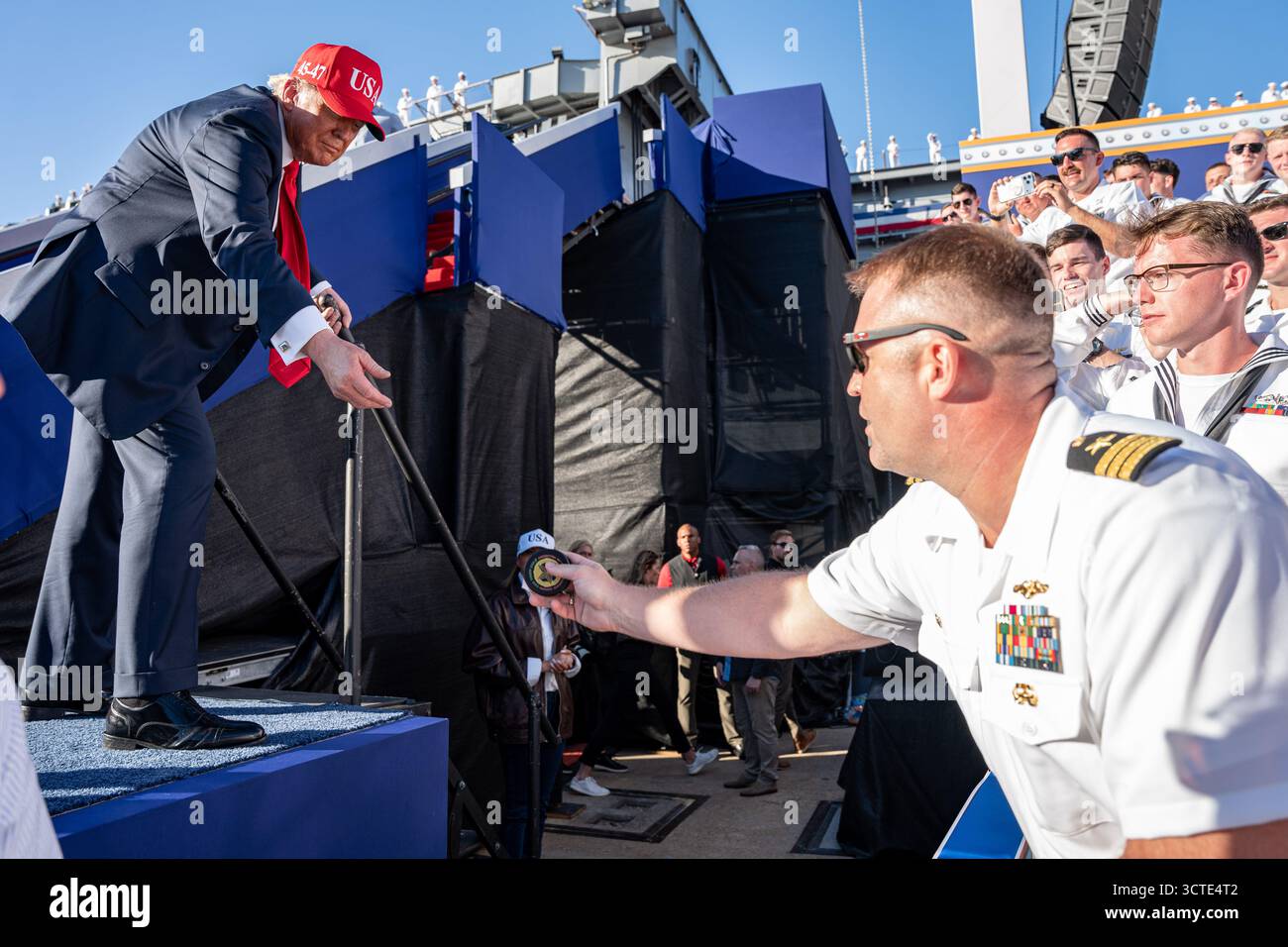 STAZIONE NAVALE DI NORFOLK, Virginia (5 ottobre 2025) – il presidente Donald J. Trump raggiunge per ricevere una moneta da sfida della Marina dopo una chiamata all Hands al molo 14, insieme alla portaerei classe Nimitz USS Harry S. Truman (CVN 75) e alla nave d'assalto anfibio classe Wasp USS Kearsarge (LHD 3), 5 ottobre 2025. L'All Hands Call at Naval Station Norfolk è uno dei numerosi eventi che si svolgono in tutto il paese per mostrare gli uomini e le donne che con orgoglio prestano servizio nella Marina degli Stati Uniti. (Foto della Marina degli Stati Uniti di Anderson W. Branch, specialista della comunicazione di massa di 1a classe) Foto Stock