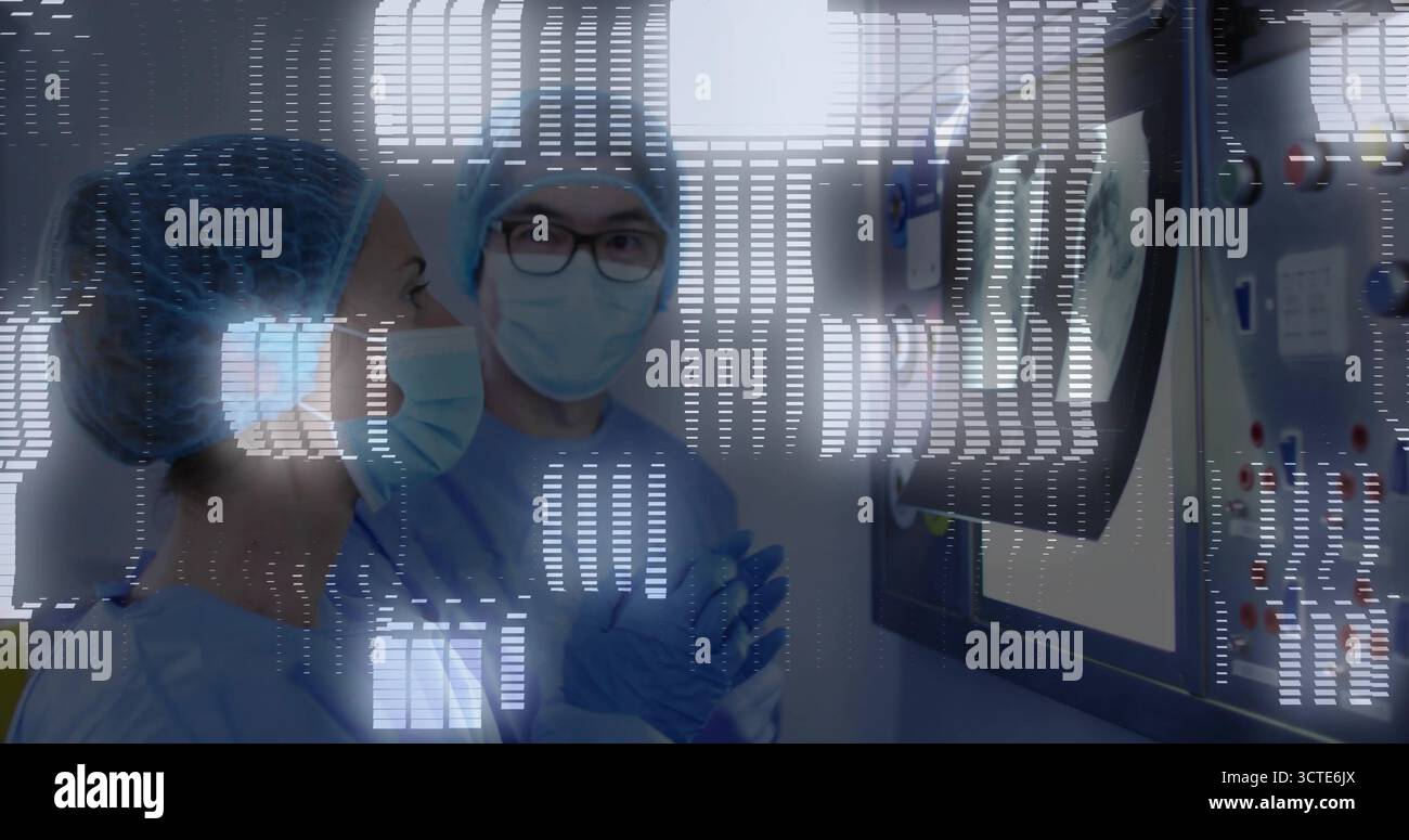 Osservazione di due chirurghi in scrub, monitoraggio dei dati in sala operatoria con monitor a parete e pannello di controllo Foto Stock