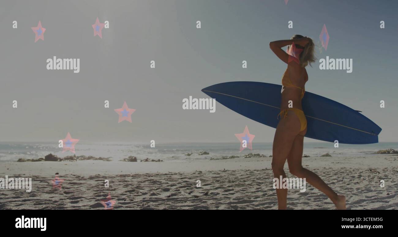 Surfista a piedi in bikini giallo che trasporta una tavola da surf blu sulla spiaggia con luce a stella e spazio per fotocopie Foto Stock