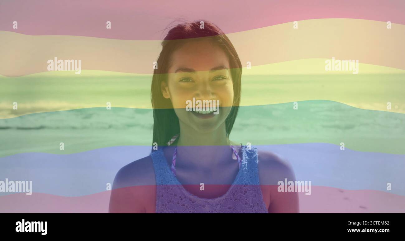 Donna asiatica in piedi che indossa canotta all'uncinetto in lavanda sopra un bikini rosa sulla spiaggia con le onde dell'oceano Foto Stock