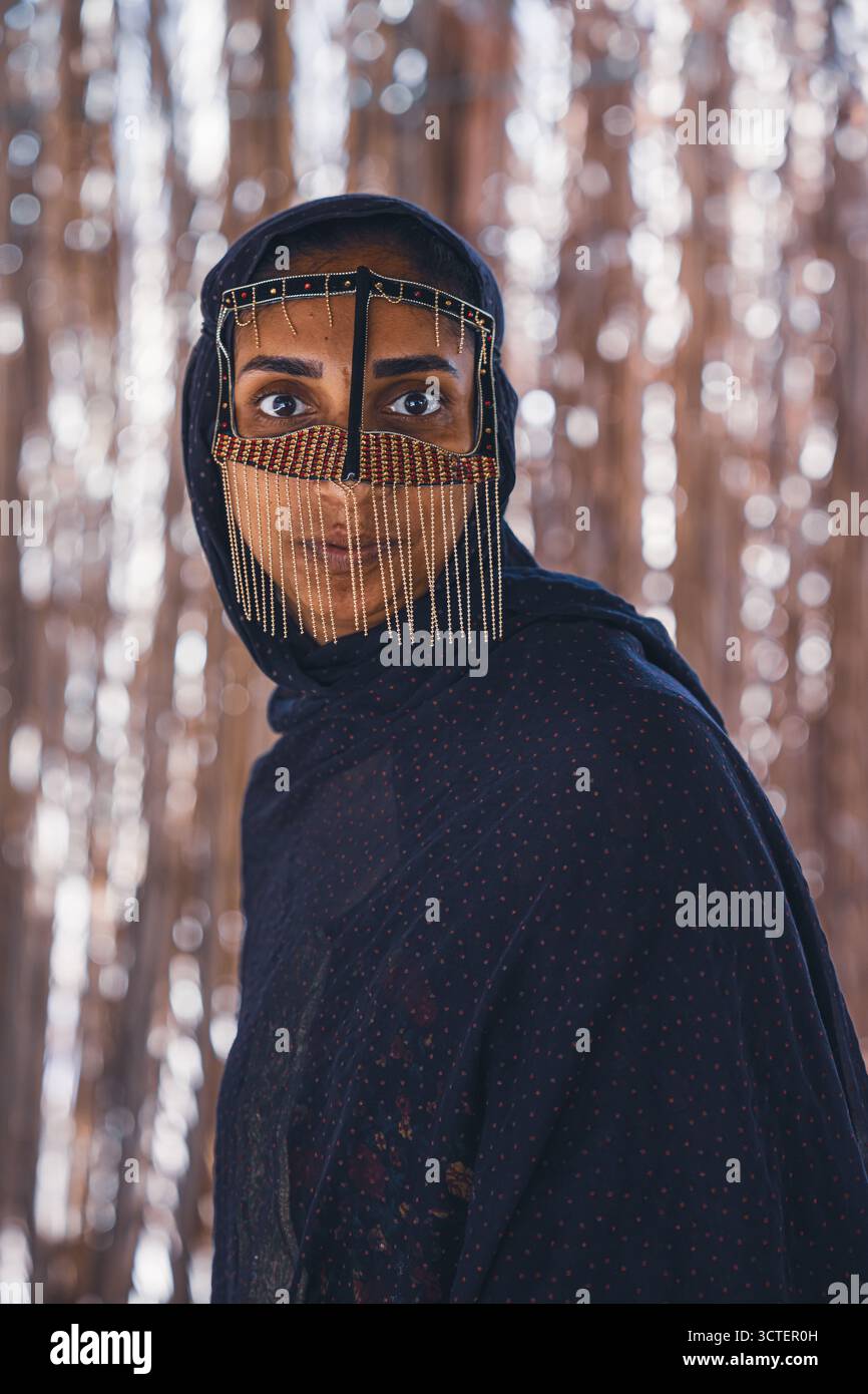 Isfahan, Iran - 01 maggio 2025: Veduta dello sguardo piercing di una donna attraverso l'intricata lavorazione metallica del suo volto, un mix di tradizione e bellezza accattivante. Foto Stock