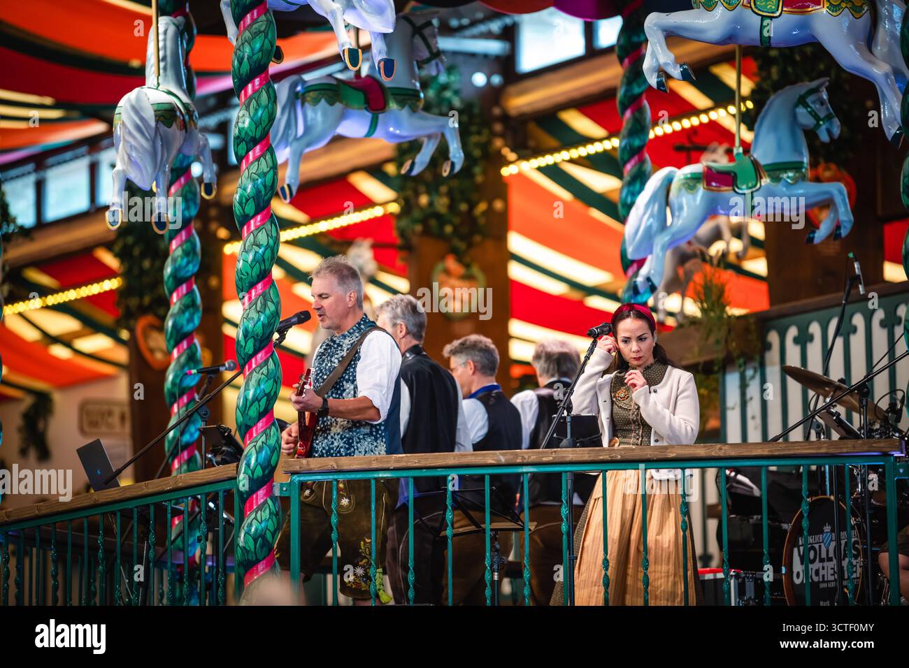 Monaco di Baviera, Germania - 18 settembre 2022: Vista della vivace Oktoberfest, dove la musica bavarese tradizionale riempie l'aria tra i colorati cavalli della giostra e le decorazioni festose. Foto Stock