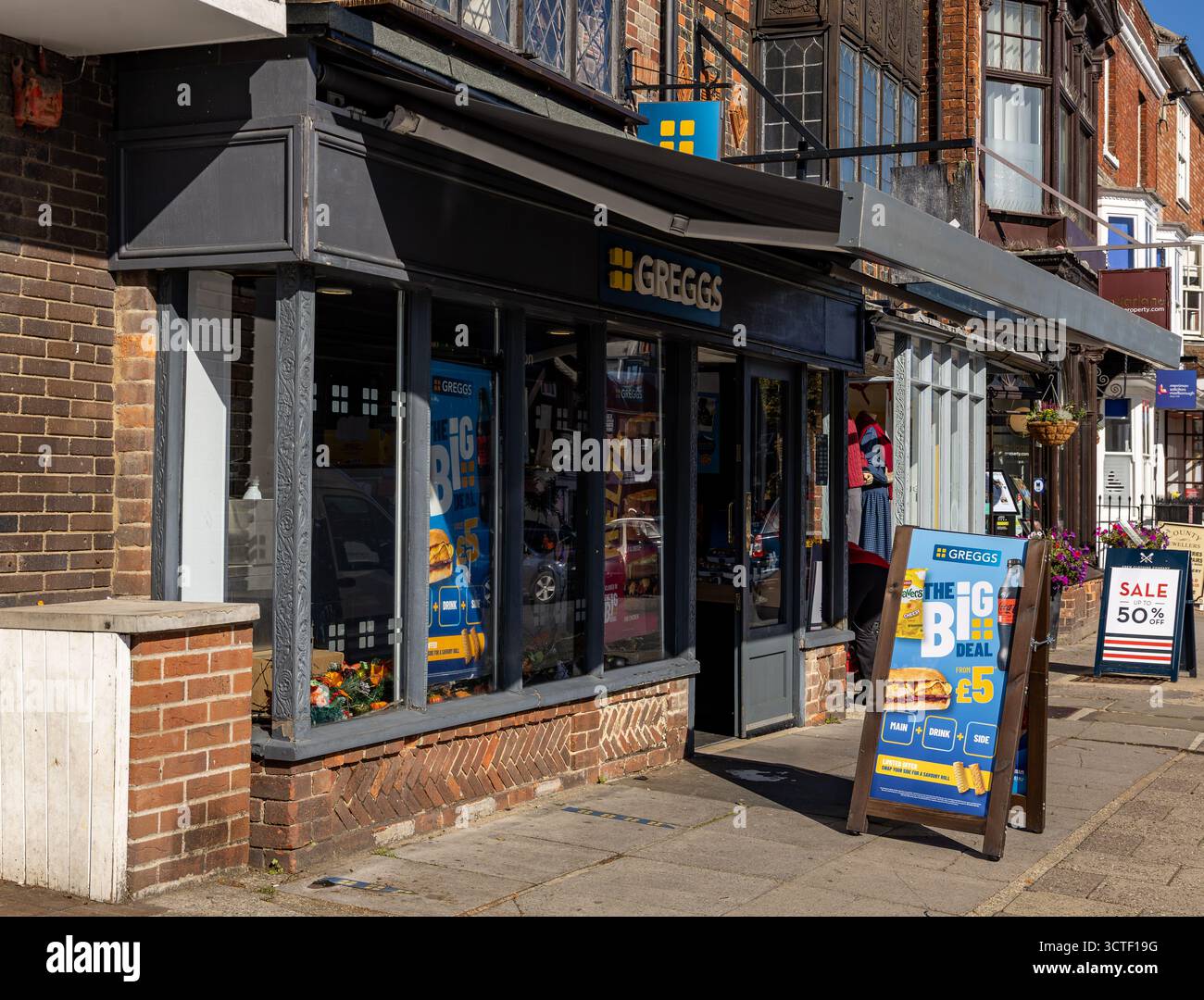 Vista sulla strada di un negozio di prodotti da forno Greggs sulla strada principale di Marlborough con cartelli promozionali per i prodotti e vendita. Foto Stock