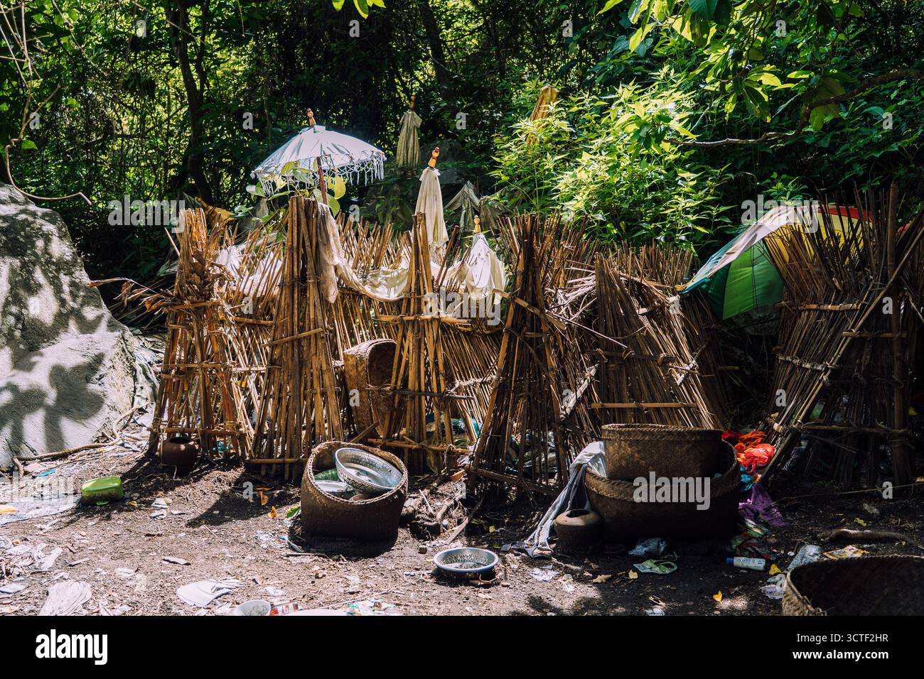 Vista dell'esclusivo cimitero Trunyan con gabbie di bambù che tengono teschi e offerte, circondato da vegetazione lussureggiante, creando una scena vibrante ma solenne, Foto Stock