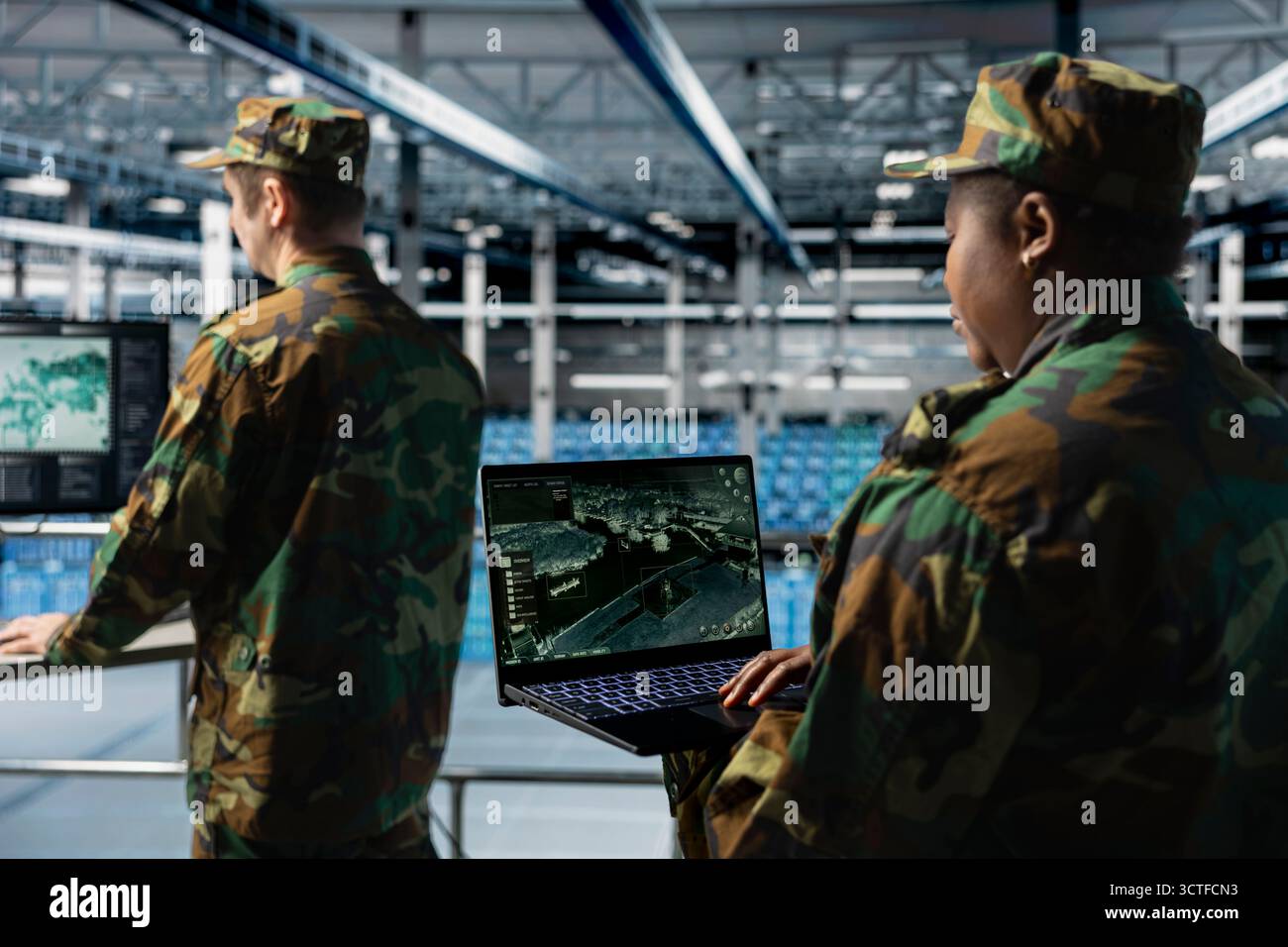 Team di esperti dell'esercito nel data center che rivede i feed di intelligence satellitari su notebook. Unità militari nel centro di comando di server farm che supportano la strategia sul campo di battaglia con l'analisi di immagini orbitali Foto Stock