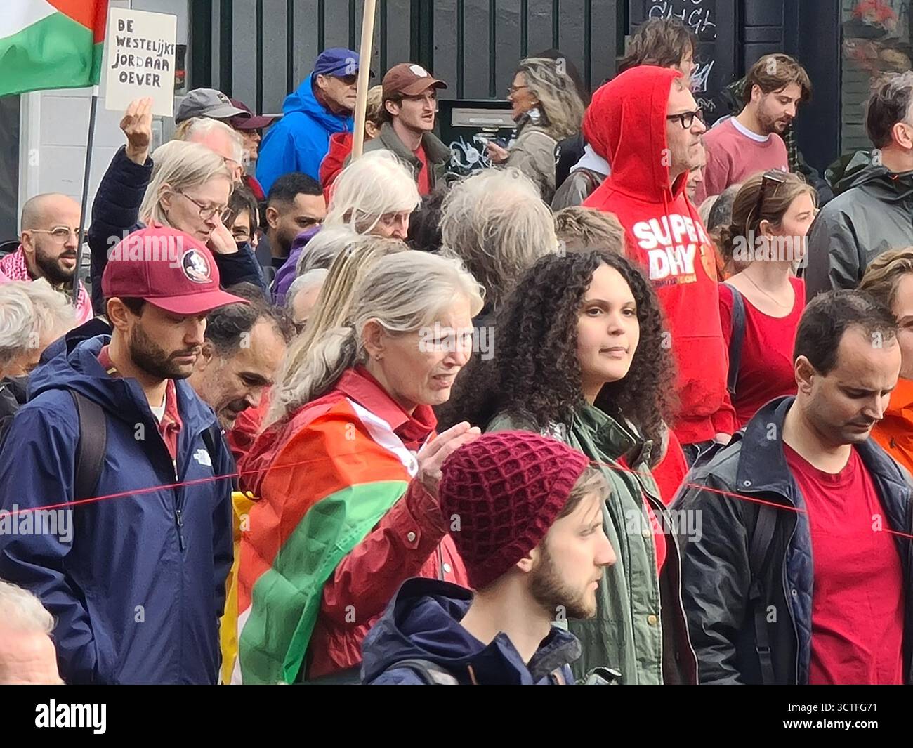 Amsterdam, Paesi Bassi. 5 ottobre 2025. Affronta op fprotest. Le persone nella folla tengono un filo di lana rossa per una lunga distanza. Crediti: Steppeland/Alamy Live News Foto Stock