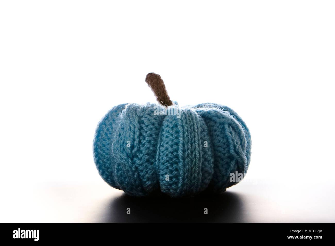 Una sola zucca blu lavorata a mano su sfondo bianco e pulito che simboleggia il raccolto autunnale, le vacanze autunnali e Halloween. Intima decorazione minimalista con Foto Stock