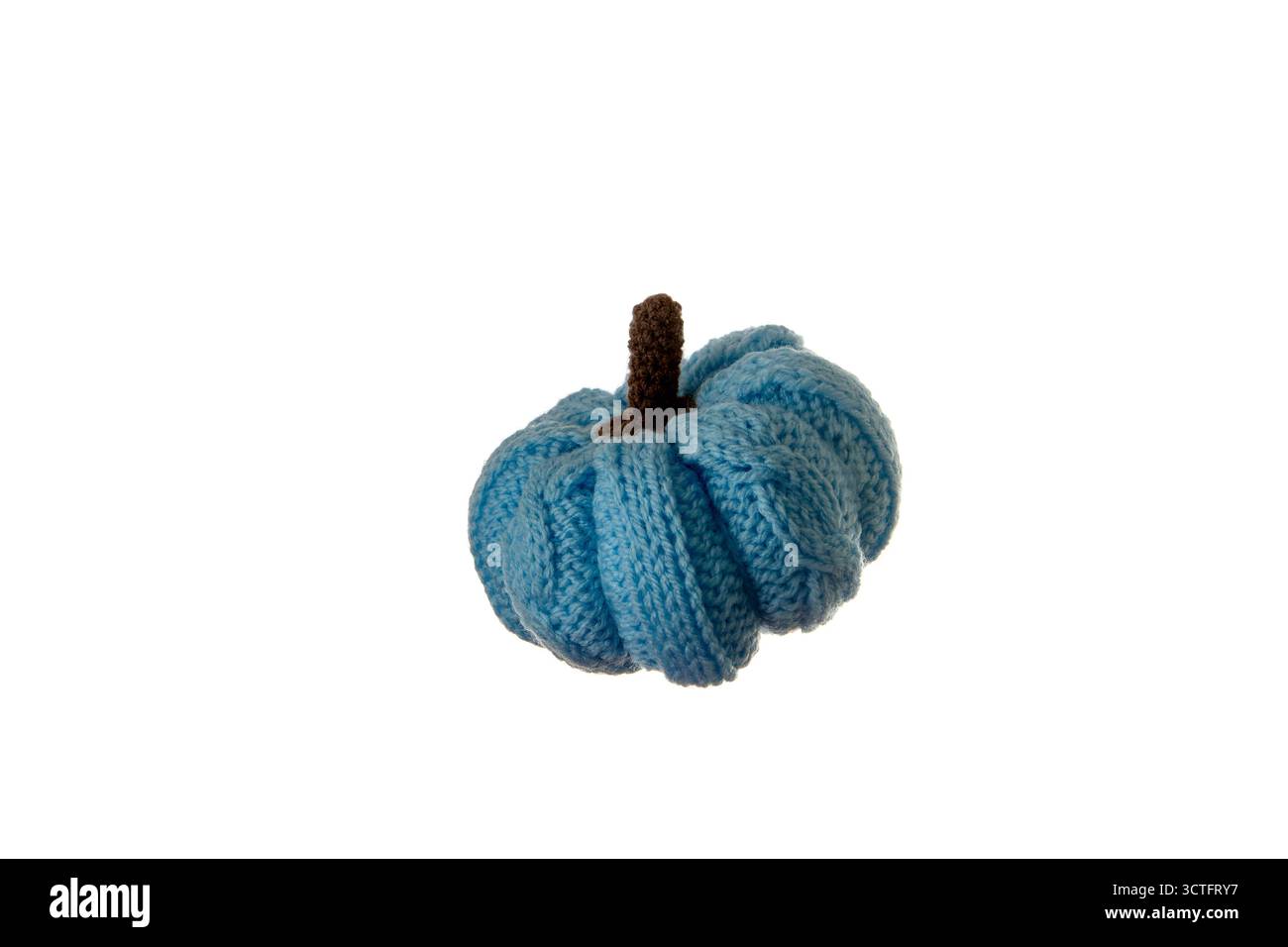 Piccola zucca blu a maglia isolata su sfondo bianco con illuminazione soffusa, ideale per decorazioni autunnali, artigianato accogliente e prodotti tessili fatti a mano p Foto Stock