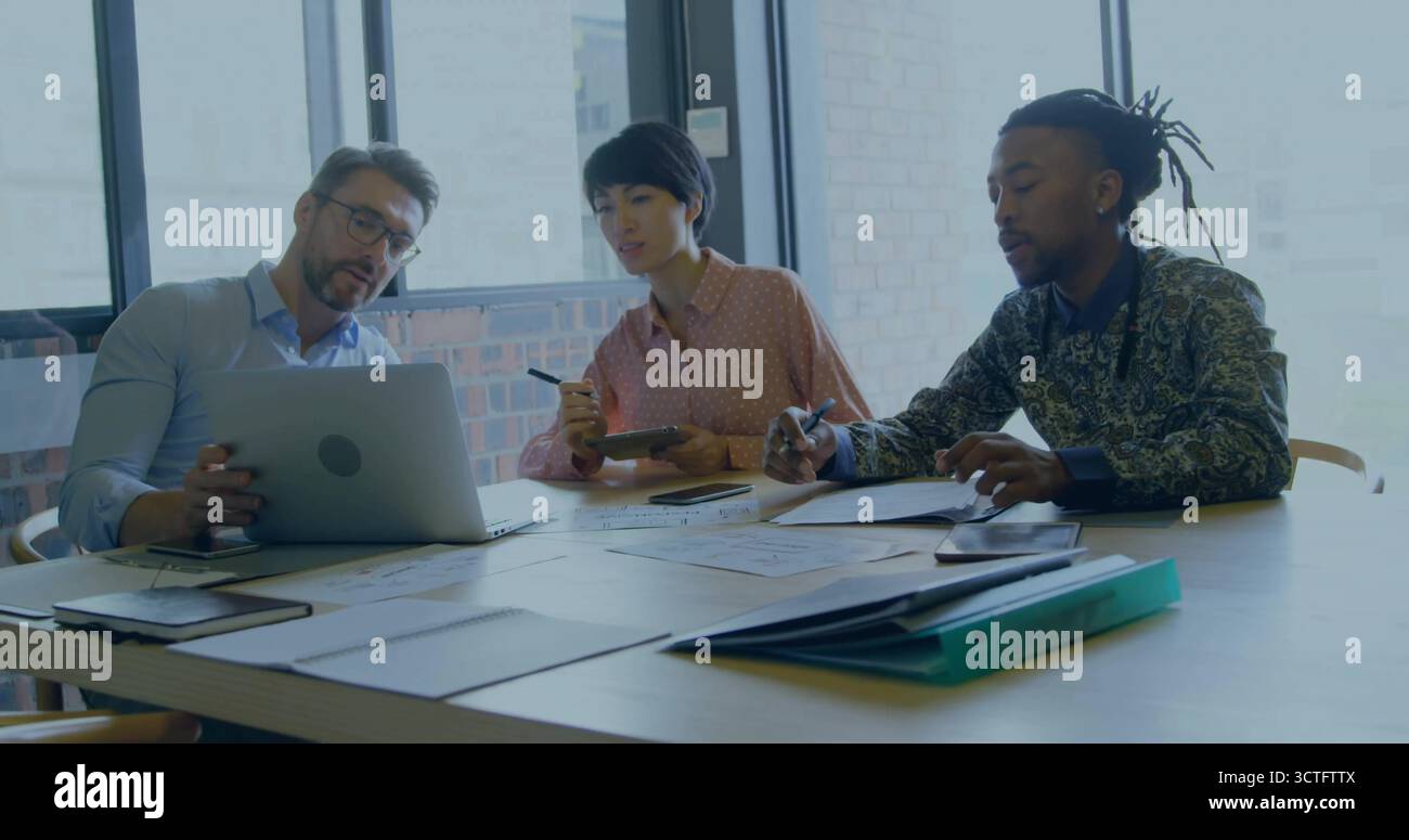 Tre professionisti che analizzano i referti in una sala riunioni con raccoglitore per calcolatrici per computer portatili Foto Stock