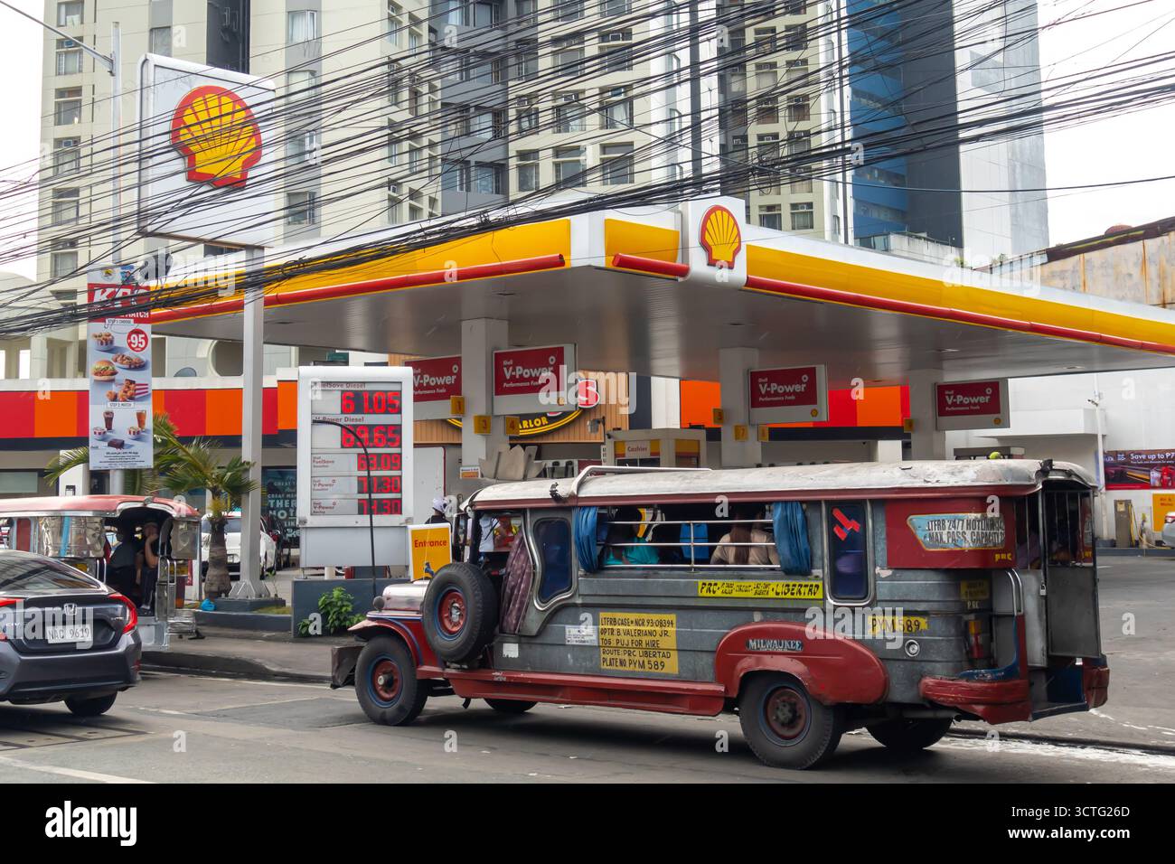 Una stazione di servizio Shell a Manila, nelle Filippine, con una jeepney in primo piano. Foto Stock