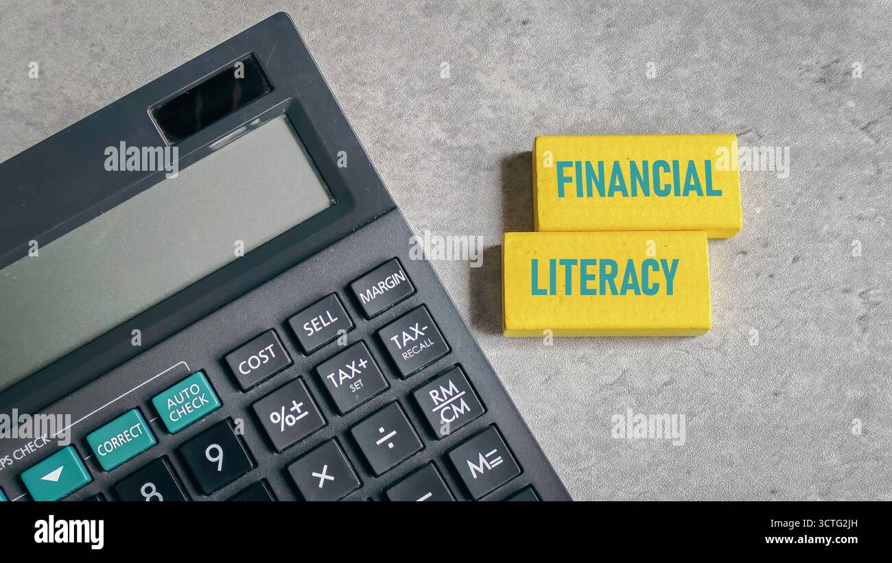 Testo di alfabetizzazione finanziaria sui blocchi gialli accanto al Calcolatore per aziende e istruzione Foto Stock