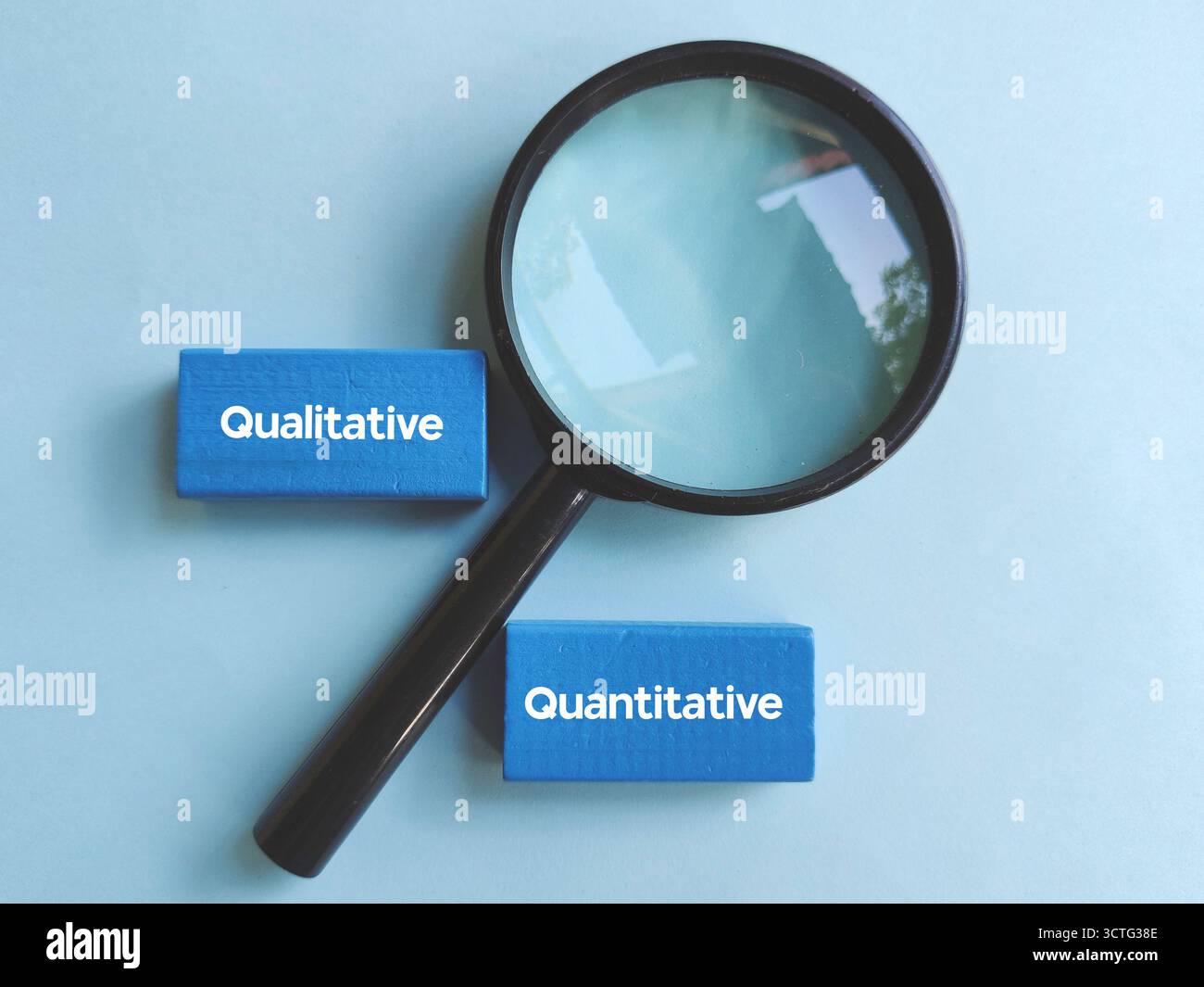 Lente di ingrandimento focalizzata sui blocchi di testo qualitativi e quantitativi che rappresentano metodi di ricerca e analisi dei dati Foto Stock