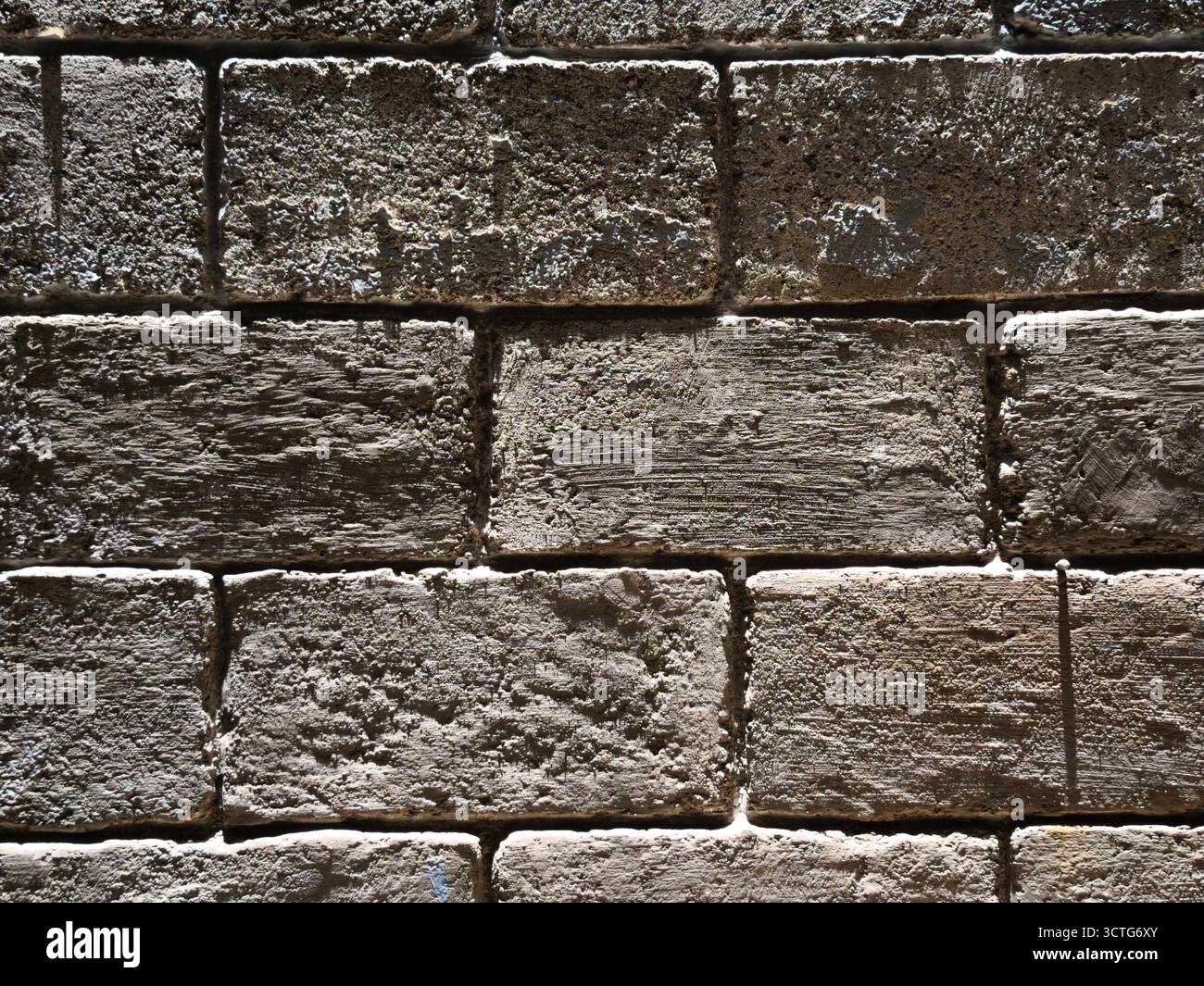 Dettaglio di una vecchia parete in mattoni con superficie ruvida e intemprata Foto Stock