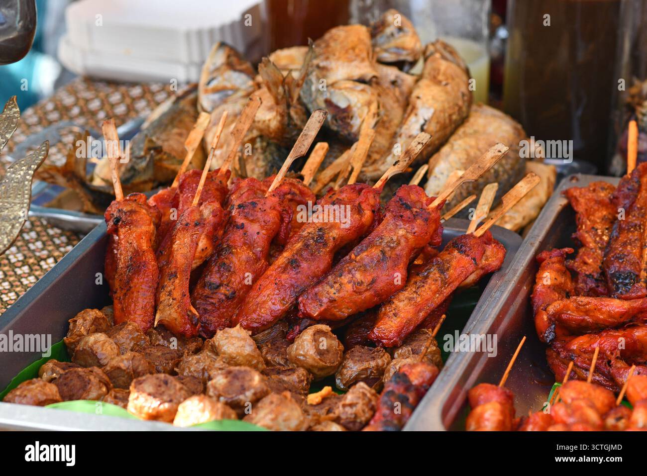 Spiedini di carne di pollo tailandese marinato rosso alla griglia al mercato Street food Foto Stock