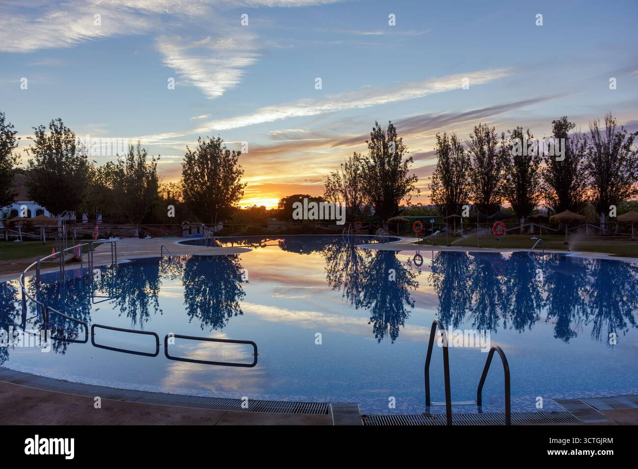 Primo piano del riflesso dell'acqua e del cielo al tramonto nella piscina del campeggio rurale di Humilladero, Málaga, Spagna. Foto Stock