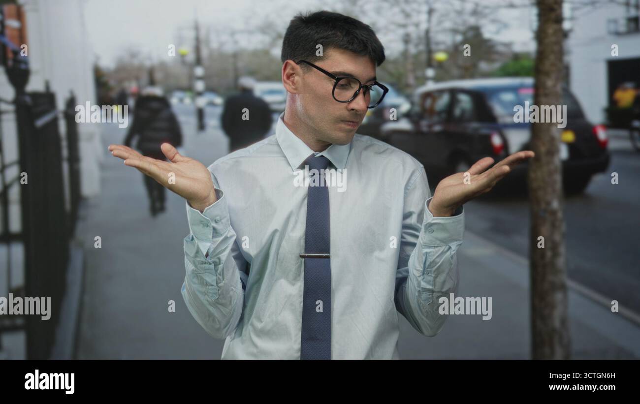 Giovane ispanico con le palme sollevate vicino al taxi parcheggiato sulla strada trafficata della città; confusione dubbio incertezza perplessità. Foto Stock