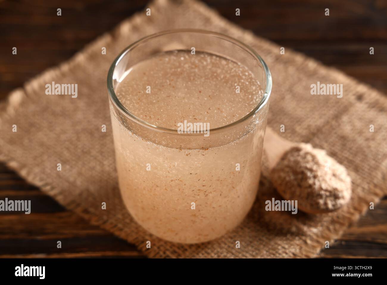 Un bicchiere d'acqua con buccia di psico sul tavolo Foto Stock