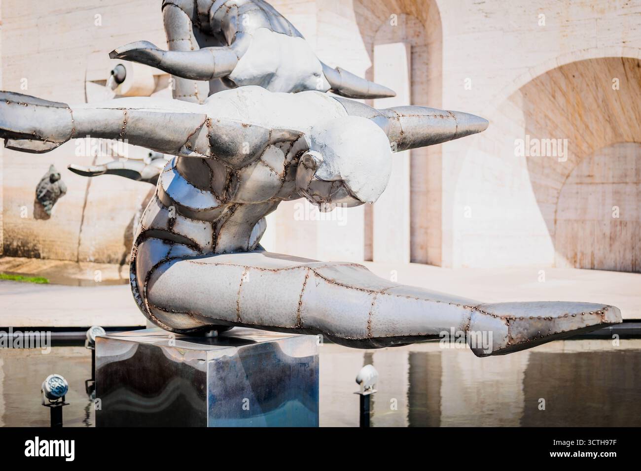 Primo piano di una futuristica scultura in metallo di una ginnasta in una posa volante dinamica presso il complesso Cascade di Erevan, Armenia, con riflessi lisci e. Foto Stock
