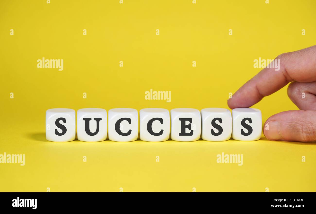 Cartello di successo con parole e lettere sui dadi bianchi. Concetto aziendale di successo su sfondo giallo. Foto Stock