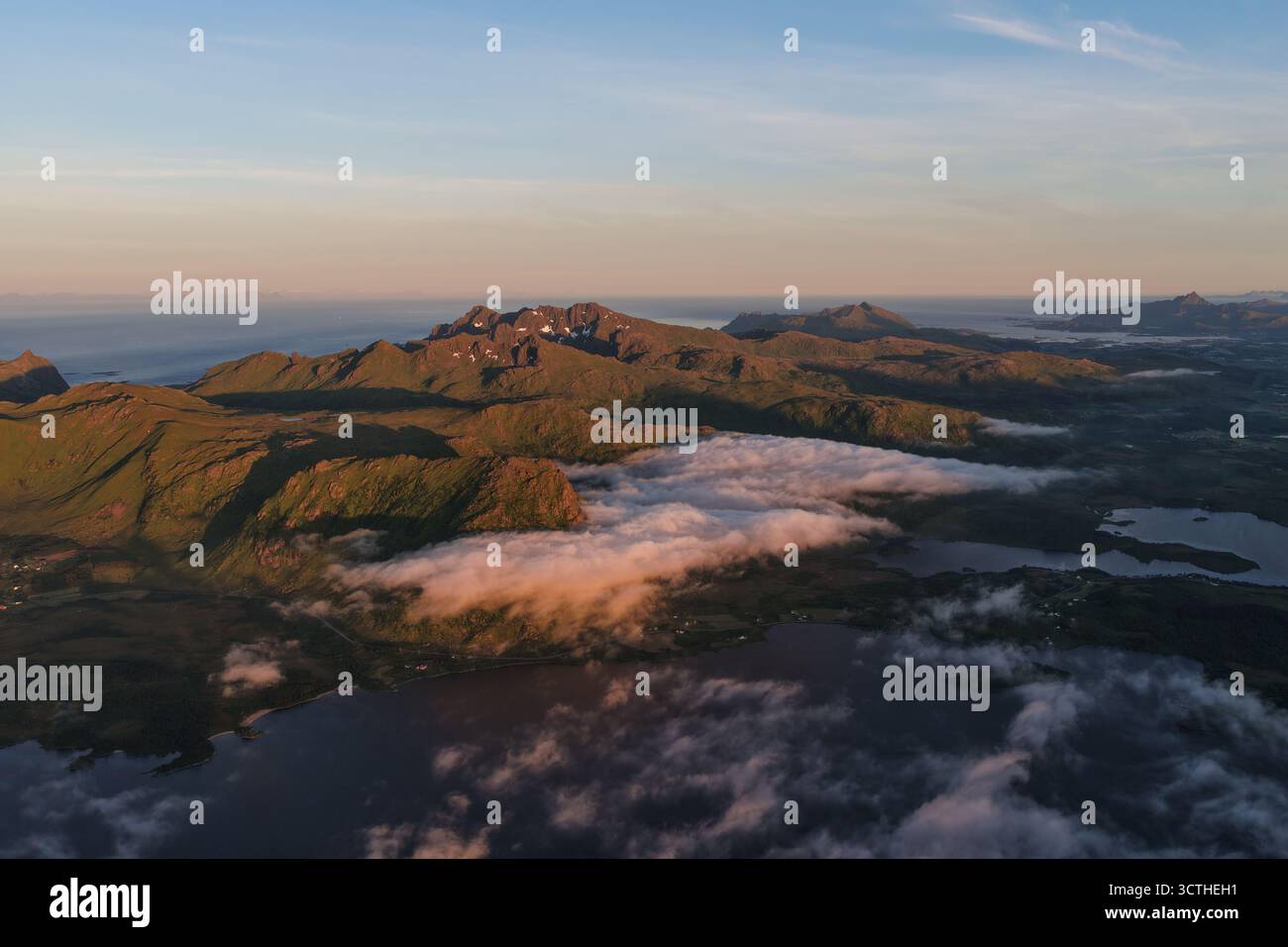 Vista aerea delle montagne lofoten che emergono attraverso le nuvole all'alba Foto Stock