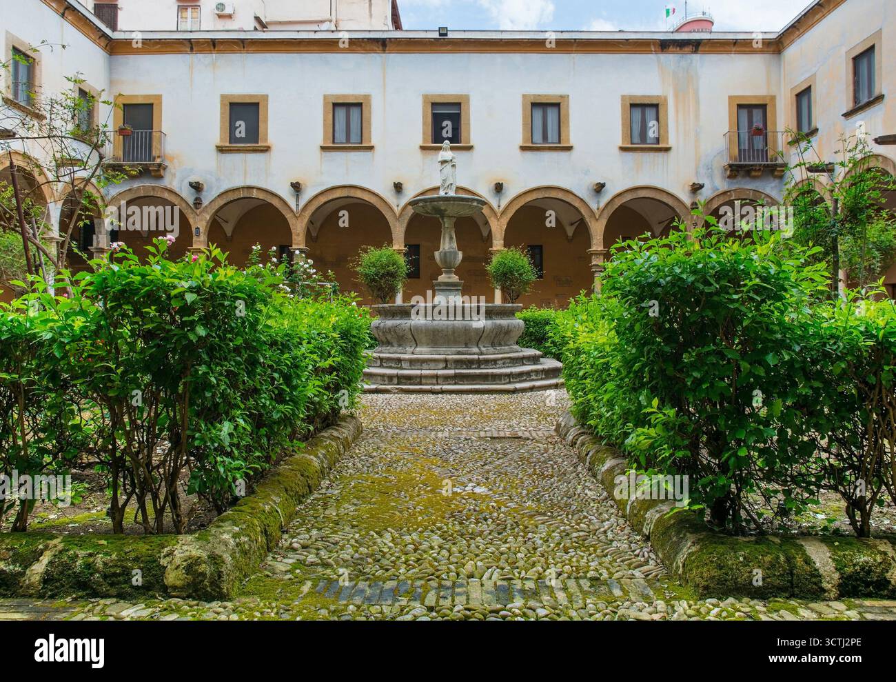 Il giardino del chiostro del Santuario Santa Rita da Cascia, chiamato anche Chiesa di Sant'Agostino, Palermo, Sicilia, Italia. Giardino verde centrale con statua Foto Stock