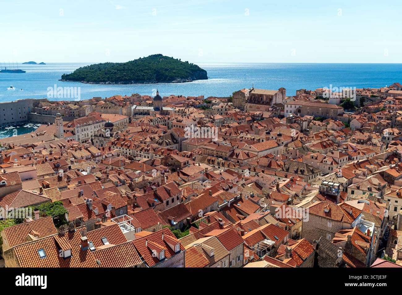Esplora i vivaci tetti rossi della città vecchia di Dubrovniks contro il mare cristallino. Foto Stock