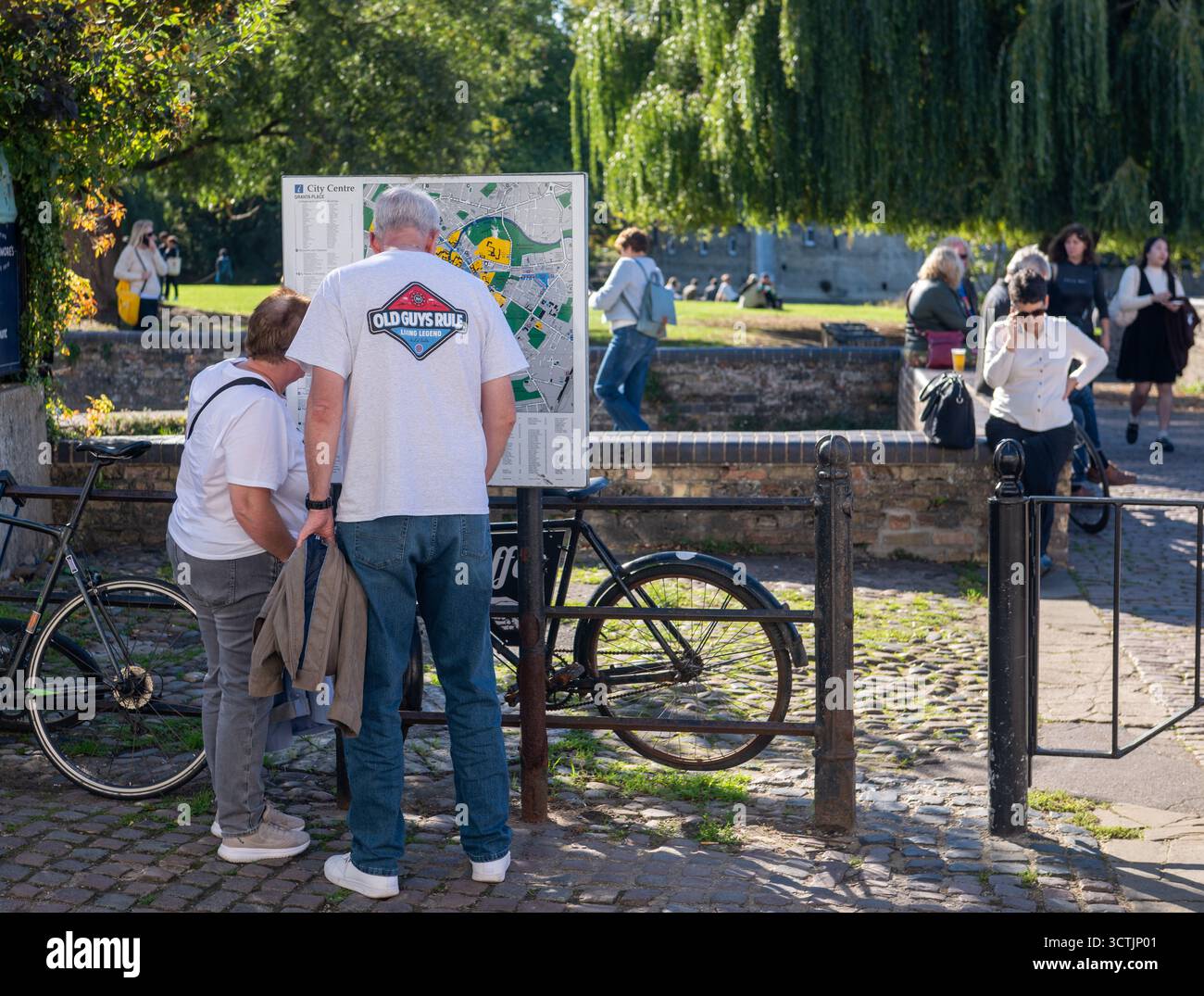 Turisti che guardano una mappa vicino a Mill Pond by the River Cam a Cambridge, giornata di sole con persone che camminano e si rilassano all'aperto, Cambridgeshire, Regno Unito Foto Stock