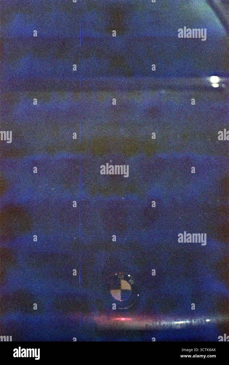 Ripresa notturna sgranata analogica di un cappuccio BMW nero, con sfumature blu sfocate nelle aree scure, creando una composizione astratta e lunare. Foto Stock